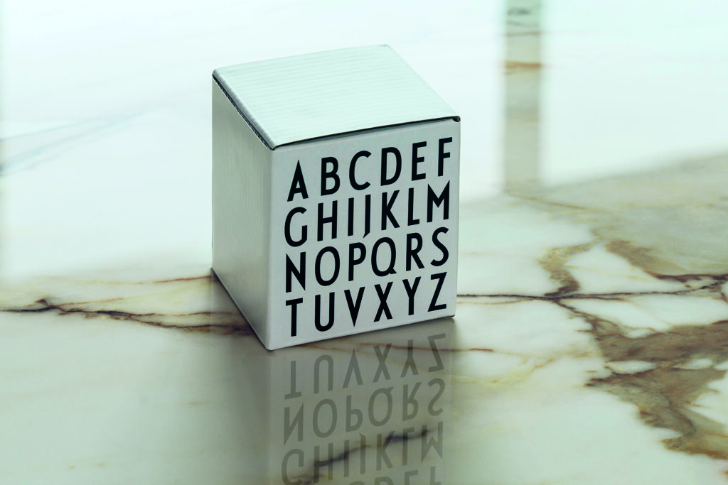 The reflection of a white cube with the alphabet on its side is clearly visible on a shiny surface, demonstrating the reflective quality of Atlas Plan Imperiale Polished finish.