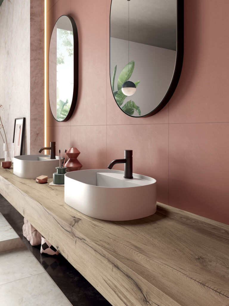 A stylish bathroom with a long wood effect countertop, supporting two oval washbasins.