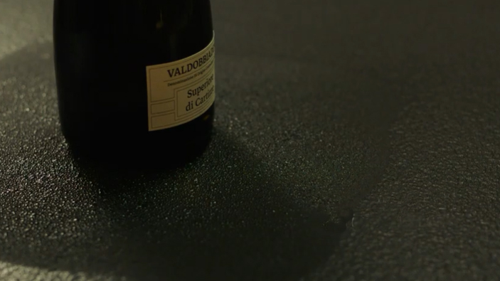 Bottle of wine resting on a cooling sintered stone countertop in a Sarasota outdoor kitchen