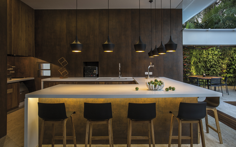 Modern Sarasota kitchen with a large island featuring a sleek, light-colored Neolith sintered stone countertop and waterfall edge.